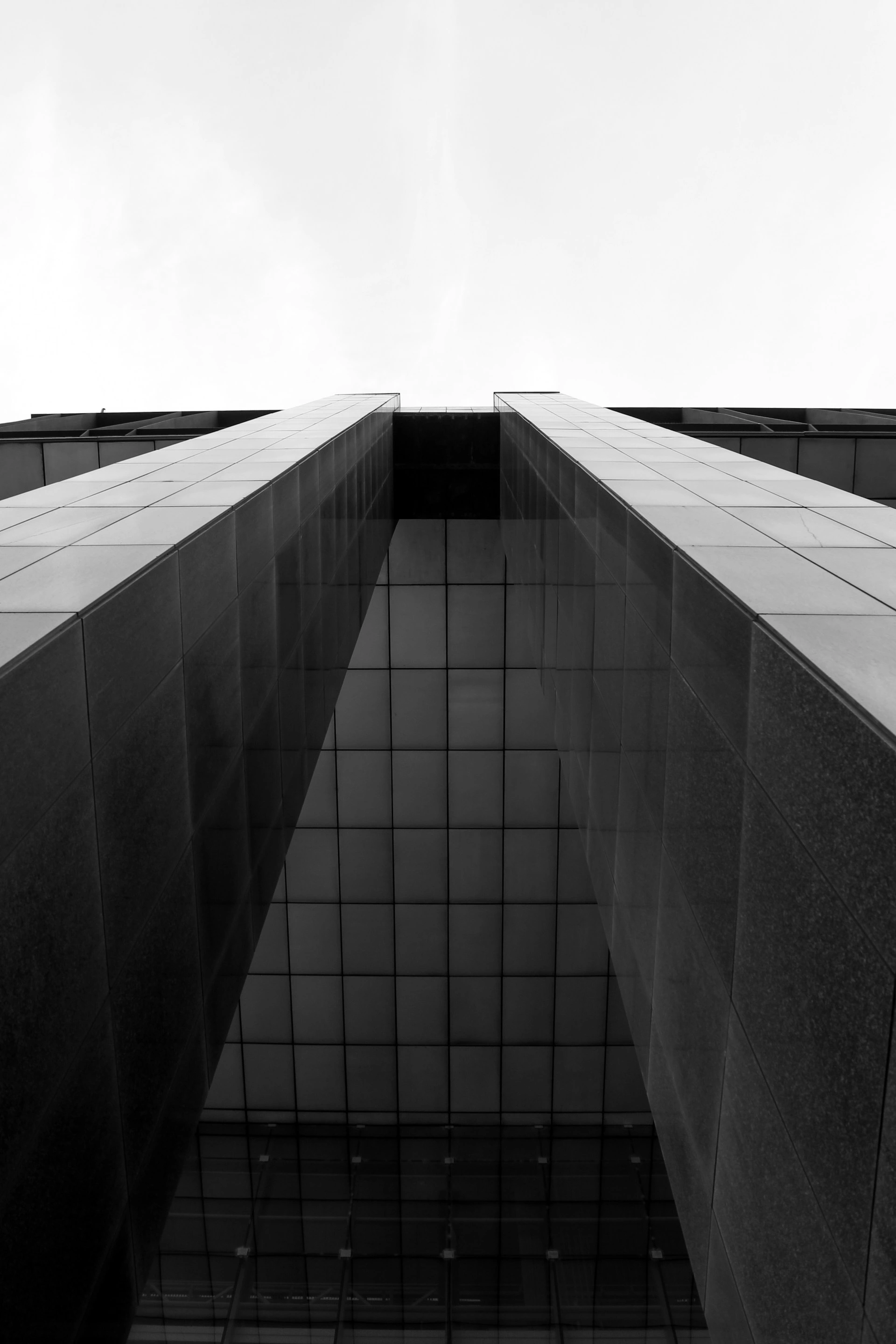 A photo taken from the street looking up at the top of a building.